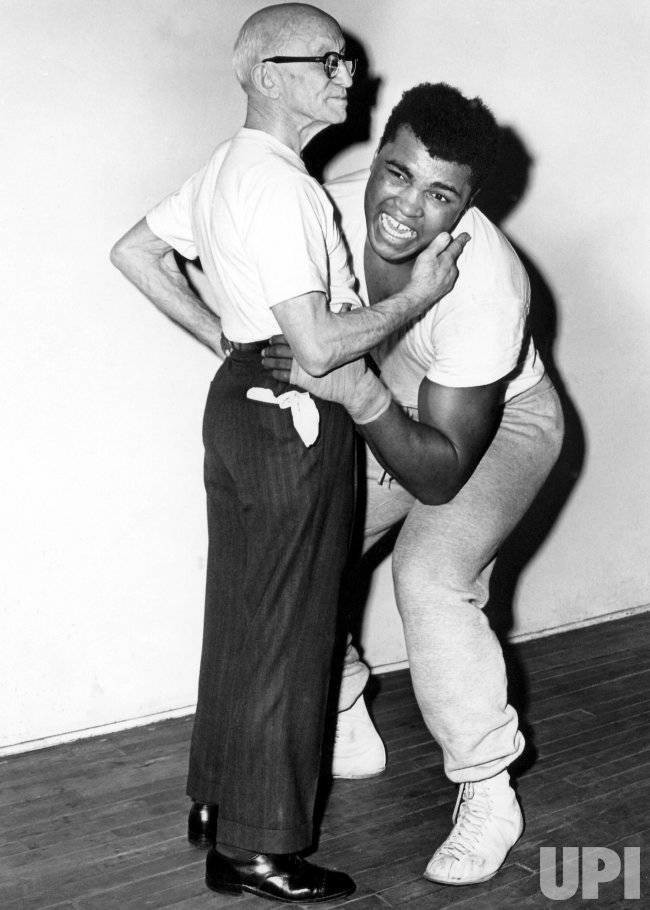 33. Мухаммед Али пытается поднять 76-летнего бывшего чемпиона мира по боксу в легчайшем весе Джонни Кулона. Он владел особым приемом: стоило ему положить палец на шею и запястье противника, тот уже не мог оторвать его от земли. 33. Мухаммед Али пытается поднять 76-летнего бывшего чемпиона мира по боксу в легчайшем весе Джонни Кулона. Он владел особым приемом: стоило ему положить палец на шею и запястье противника, тот уже не мог оторвать его от земли.